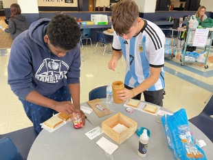 Seniors Hans Petit Frere (left) and Alexander Brandon (right) create PB&J sandwiches to donate to homeless people in Newark on Monday, Dec 19, in the high school Commons. 