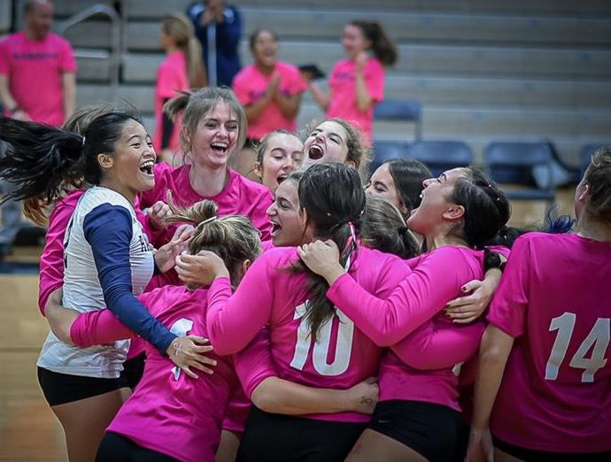 Members of the girls varsity volleyball team celebrate after winning their Dig Pink game against Morristown in three sets on Oct. 4, 2022. 
