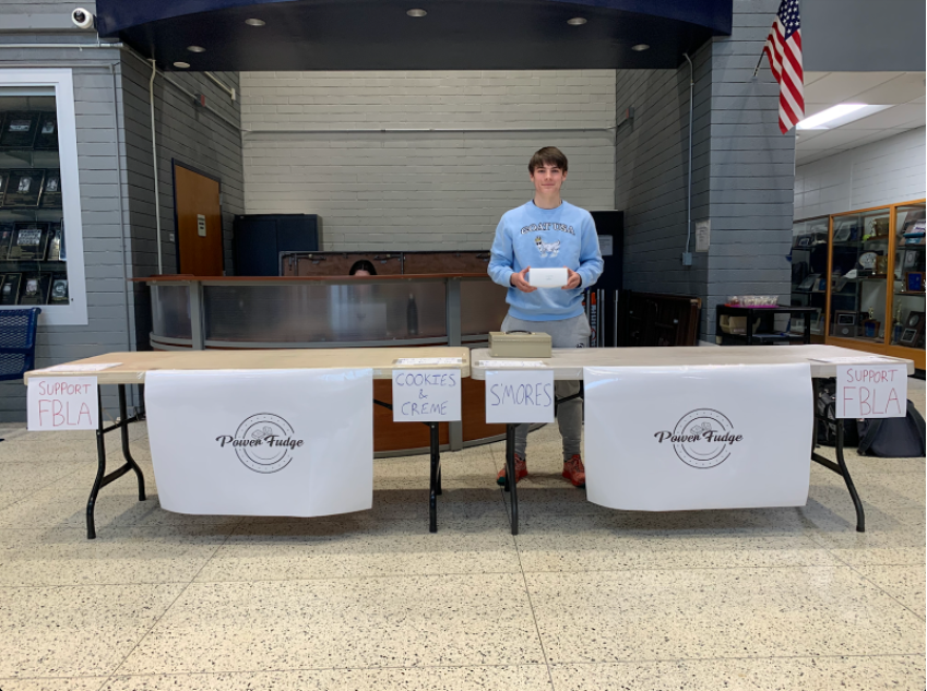 Zach Power stands at his sold-out table of “Power Fudge,” at a fundraiser for the Future Business Leaders of America (FBLA), held in the main lobby of the high school on Dec. 16, 2022.