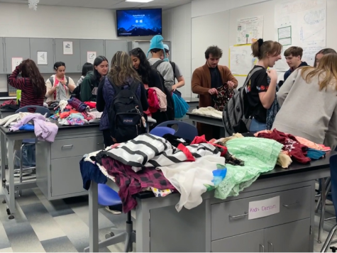 Students search for free clothes and accessories at the Thrift Shop event, held at the high school during Earth Week, on Tuesday, April 18, 2023.