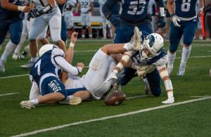 Logan Hankin forces a fumble, and Matt Skrapits fights to recover it.

