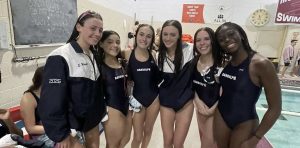 From left: Junior Sydney Wright, freshman Angelica Sandoval, freshman Taylor Holzman, junior Alivia Wright, freshman Emily Dalton and senior Kisa Mulondo group together after the Girls Swimming season-opener win against Morristown. 
