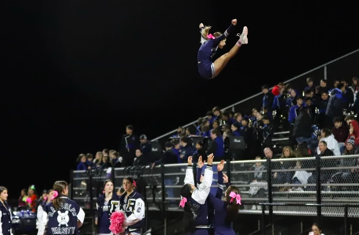 Freshman varsity cheerleader Cate Glauberg is thrown into the air during a football game this season.