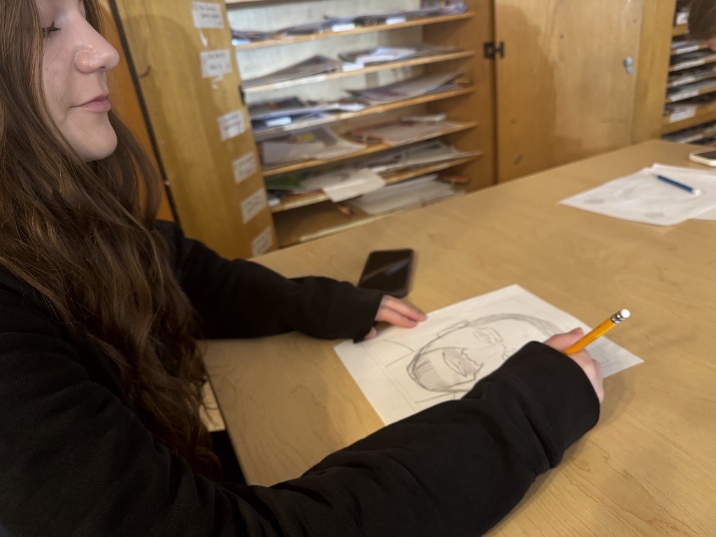 Junior Katie Esposito sketches a portrait in Mr. Montone's painting class, her favorite.