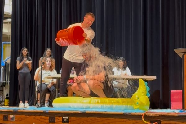 Social Studies Teacher Jacob Torsiello takes the Ice Bucket Challenge, with an assist from colleague Erik Novack, to help raise money for child cancer research in the high school auditorium on Friday, May 2, 2025. 