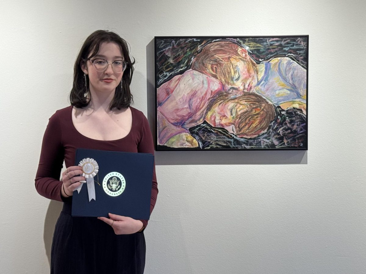 RHS junior Sarah Hall stands next to her award-winning piece, “Sister,” with her United State Congress certificate in hand.  

