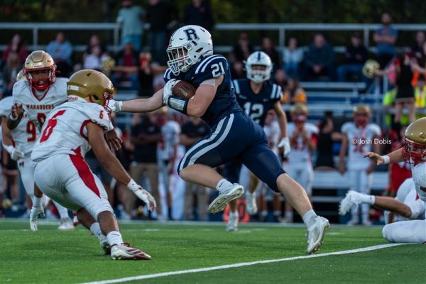 Sophomore Dillon Hines (21) pushed away the Mount Olive defender to run down the field on the way to a 43-7 loss on Friday, Sept. 12, 2025.