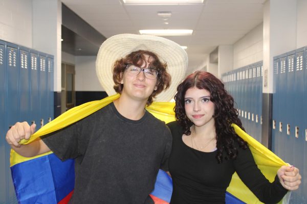 From left: Juniors Ava Pinho and Mariana Orjuela wrap themselves in the Colombian flag during Hispanic Heritage Spirit Week, held at RHS from Monday, Oct. 6, through Friday, Oct. 10, 2025.