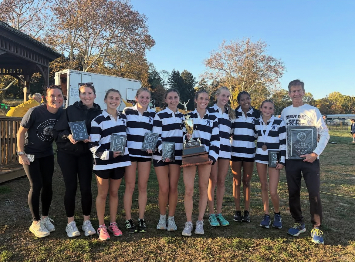 Coach Moran (left) poses with the Girls X-C team after winning the Morris County Championships on Oct. 21, 2025. At right is Head Coach Kevin Higgins.