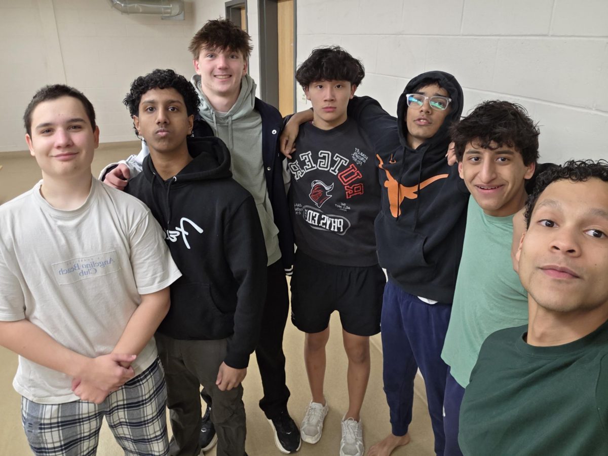 Boys Swimming poses for an after-practice picture as the team gears up for the final meets of the season. From left: Seniors Ilya Andrianov and Elijah Jacob; juniors Gavin Drazek and TJ Wangchuk, senior Raihan Prakash, junior Gabriel Diaz and senior Marco Holder.