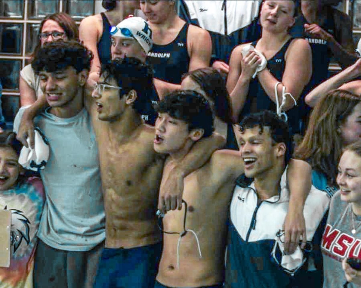 Members of the Boys Swim team and alumni group together to cheer on the team at a home meet against Morris Hills on Wednesday, Dec. 17, 2025. From left: Alumnus Michael Diaz, senior Raihan Prakash, junior TJ Wangchuk, senior Marco Holder, and alumna Ana Saguillo Leppanen.