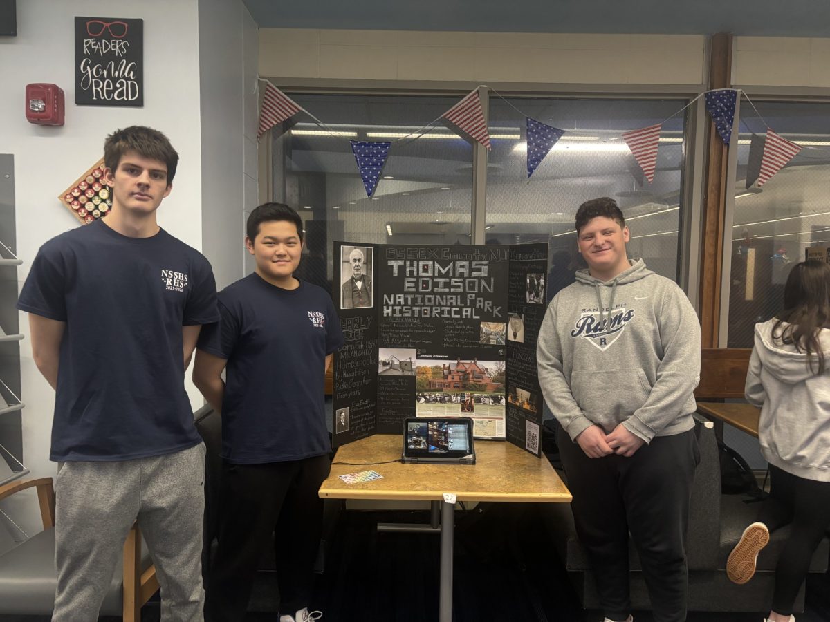 From left: Brayden Hendrickson, Ryan Shin and Ben Frick present their trifold on the Thomas Edison National Historical Park at Red, White, & Jersey at RHS on March 5, 2026.