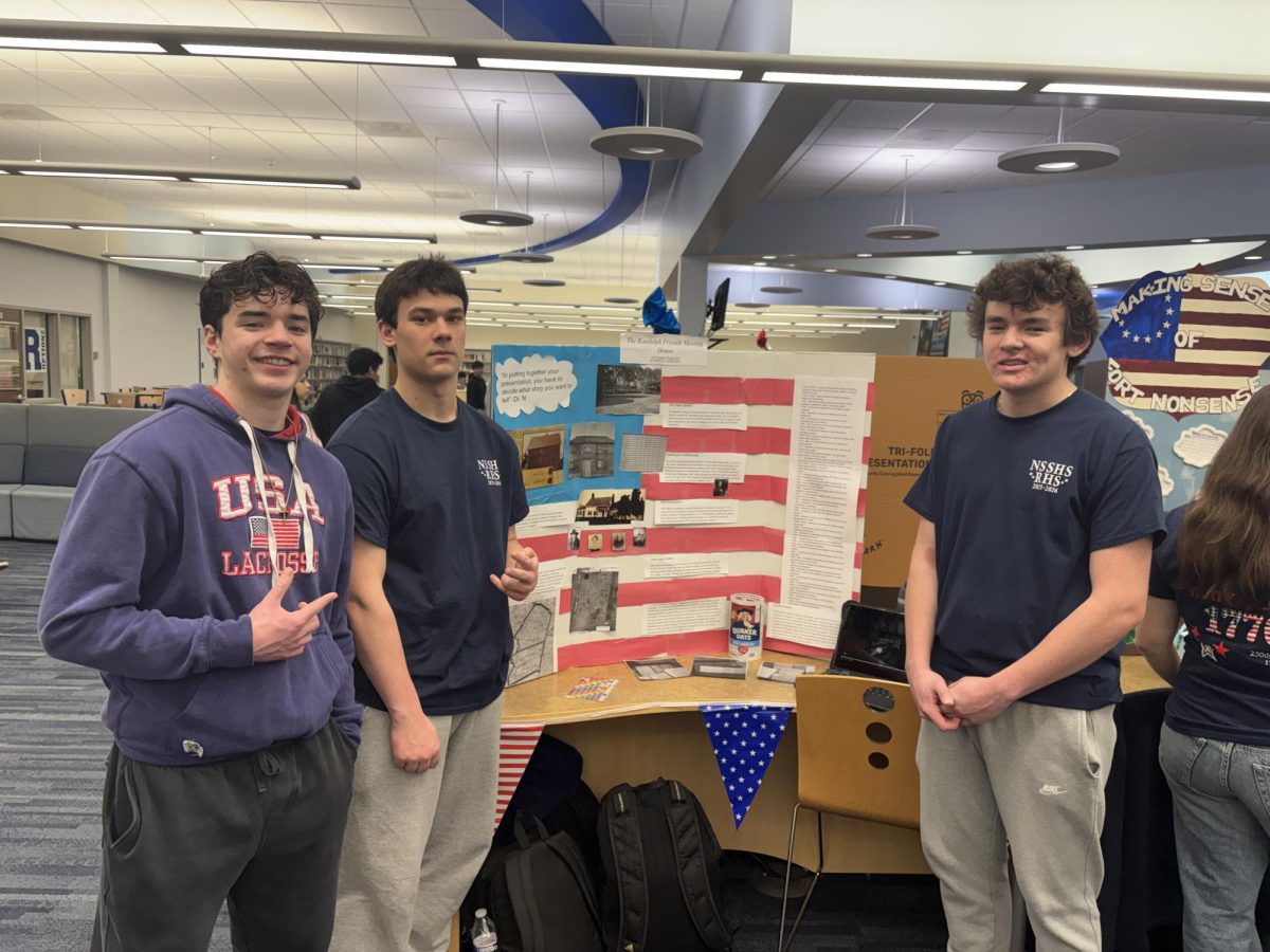 From left: Jack Novak, Ryan Walsh and Mark Hurley present their trifold on the Randolph Friends Meetings House at the Red, White, & Jersey event at RHS on March 5, 2026. 
