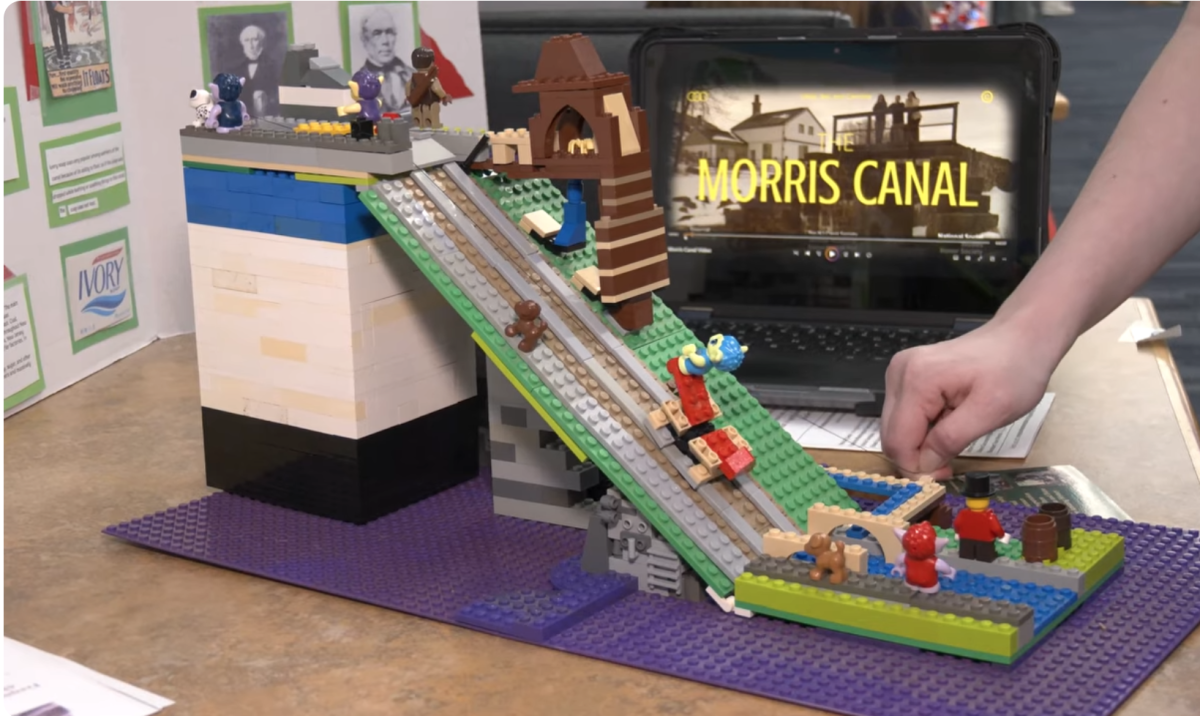 Using LEGO bricks, a student presenter demonstrates how the historic Morris Canal used an inclined plane system to move boats past elevation changes during the Red, White, & Jersey event on Thursday, March 5, 2026.