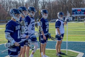 Varsity Boys Lacrosse players (from left) Mark Manolis, Cole Miller, Justin Novak, Ryan Barnett and Nick Cirella meet at the middle with the opposing team before the start of a recent game during the 2025-26 season.